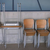 重ねられた学校の机と椅子が並ぶ双葉みらい学園の教室の写真