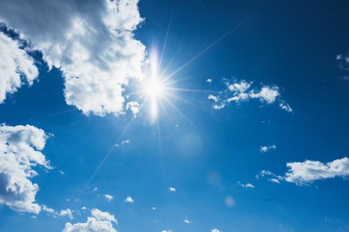 青空に輝く眩しい太陽と白い雲