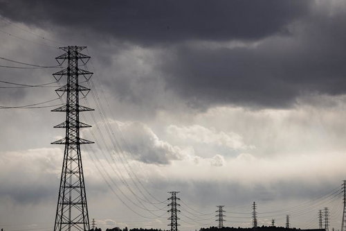 曇り空に並ぶ鉄塔と送電線