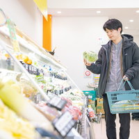 小高ストアの野菜コーナーで食材を選ぶ男性の写真