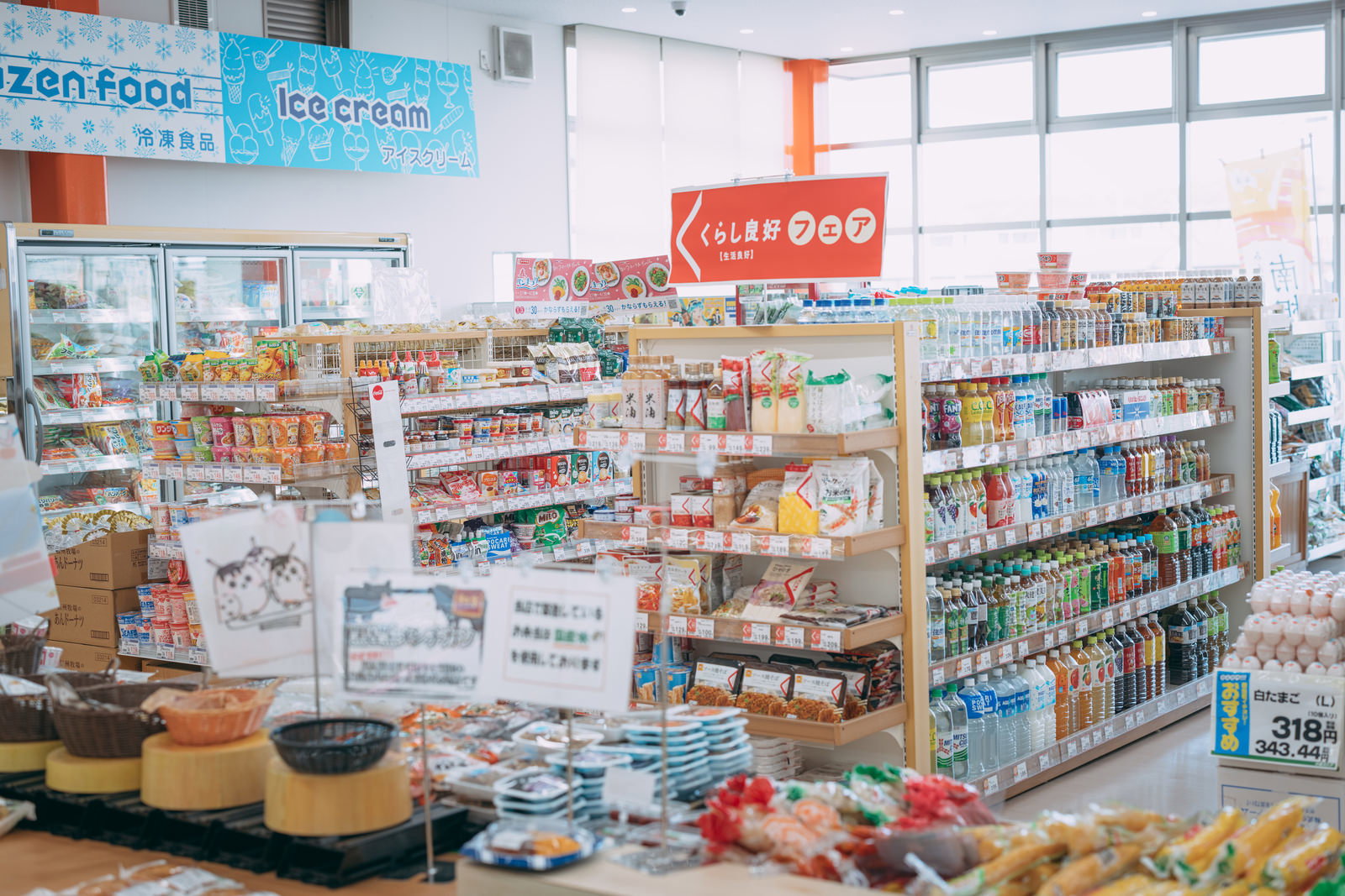 小高ストアの店内で、木製の棚に並ぶ缶詰や調味料などの商品