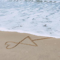 波打ち際に描かれた相合い傘 - 砂浜の儚い恋愛表現の写真