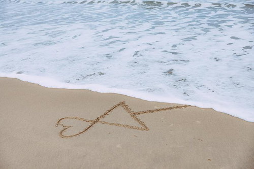 波打ち際に描かれた相合い傘 - 砂浜の儚い恋愛表現