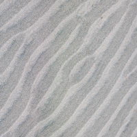 砂浜に刻まれた波跡の模様と光と影のテクスチャーの写真