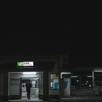 終電間際の広野町駅前で切符を買う乗客の夜間風景の写真