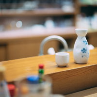 木製のテーブルで熱燗を飲む日本酒の一杯の写真