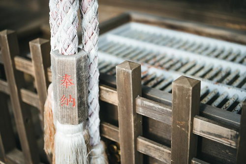 神社の賽銭箱に奉納された白い綱と折り紙の装飾