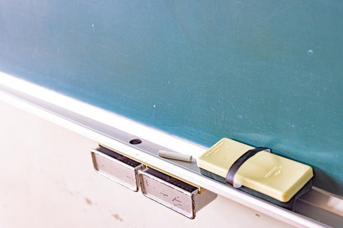 廃校舎の教室に置かれた黒板と黒板消しの風景