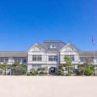 歴史を刻む旧遷喬尋常小学校の白い洋館校舎の写真