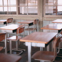 旧遷喬尋常小学校の教室に並ぶ学習机と椅子の写真