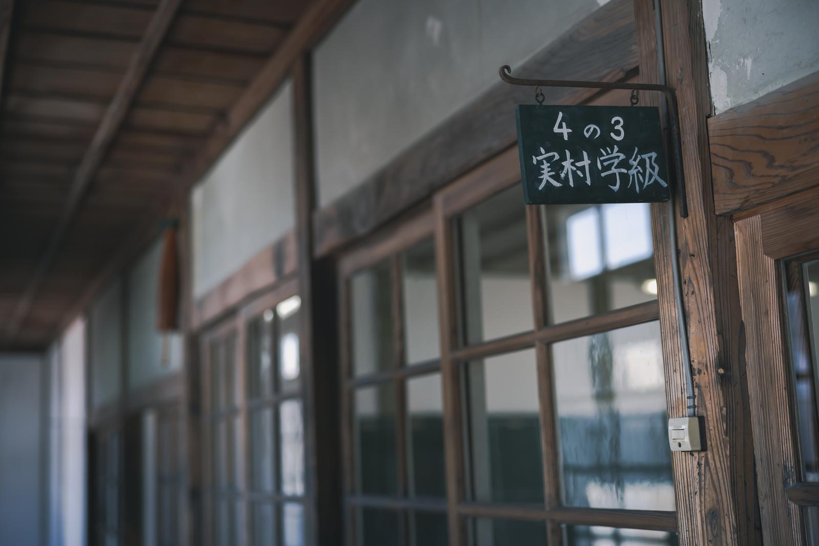 旧遷喬尋常小学校の廊下に掛かった緑色の学級表示板と木製建具
