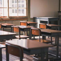 放課後の学習机と椅子で満たされた旧校舎の教室の写真