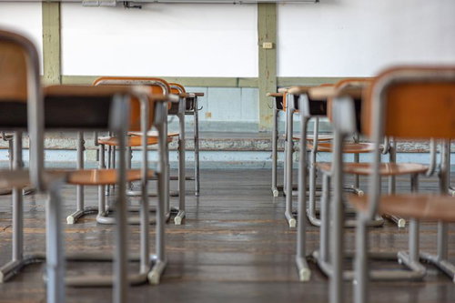 旧遷喬尋常小学校の教室に並ぶ木製の学習机と椅子