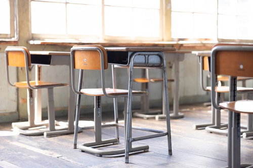 明るく照らす教室の学習机と椅子の風景～旧遷喬尋常小学校