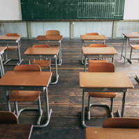 旧遷喬尋常小学校の教室に並ぶ学習机と椅子の写真