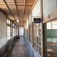 放課後の旧遷喬尋常小学校、木造校舎の廊下の静寂の写真