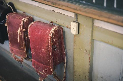 旧遷喬尋常小学校の教室に吊るされた使い古されたランドセル