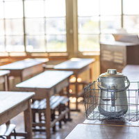 旧遷喬尋常小学校の教室に置かれた給食食器と学習机の風景の写真