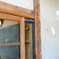 木製の古い校舎の扉上に仕掛けられた黒板消し落としのいたずらの写真