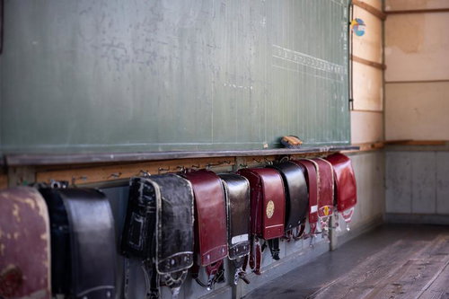 古い教室の黒板の前に並ぶランドセル - 昭和レトロな学校