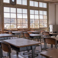 旧遷喬尋常小学校の教室の窓と学習机、木製格子窓からの眺望の写真