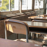 窓際の学習机と椅子が並ぶ教室の学習風景と木製机の写真