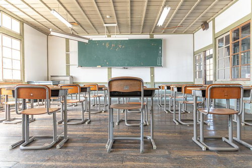 窓を望む旧遷喬尋常小学校の教室と学習机・黒板