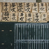 岡山県の旧遷喬尋常小学校で掲示された「芽吹」の書初め作品と黒板の写真