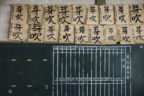 岡山県の旧遷喬尋常小学校で掲示された「芽吹」の書初め作品と黒板