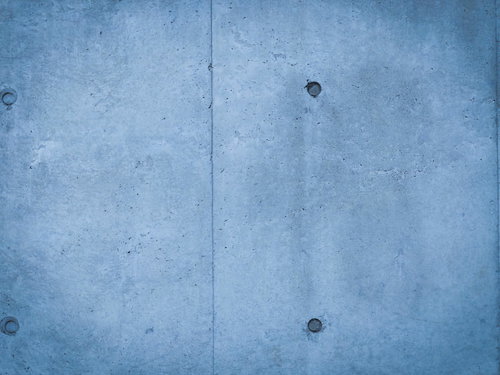 黒ずんだセパ穴が規則正しく並ぶコンクリート打ちっぱなし壁