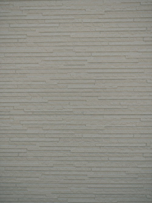 グレーの凹凸ある建材タイルを使った外壁の壁面テクスチャー