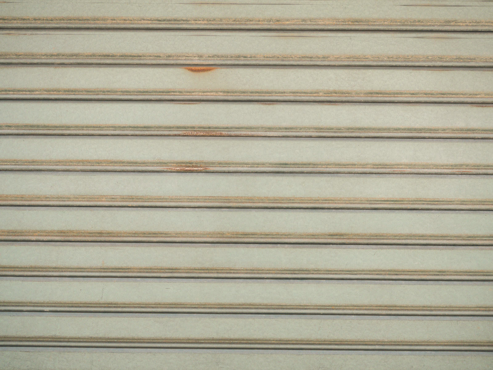 ベージュから薄茶色の横縞模様が規則正しく並ぶ金属製シャッター