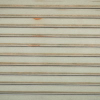 目立たない錆が浮かぶベージュ色のシャッターの写真