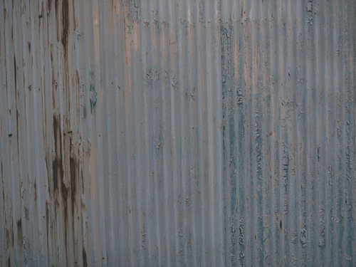 塗装が劣化してボロボロになった波板のテクスチャ