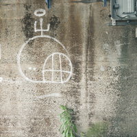 白い落書きが描かれたコンクリート擁壁のテクスチャの写真