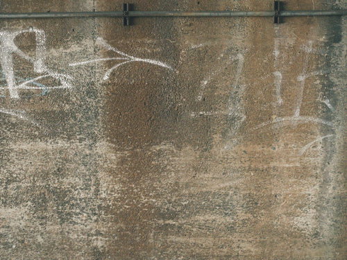 コンクリート擁壁に描かれた白いスプレー落書き