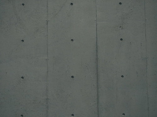 規則正しく整列したPコン穴のコンクリート壁テクスチャ