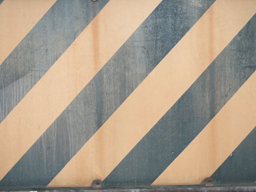 警戒色の縞模様が斜めに配置された壁のテクスチャー