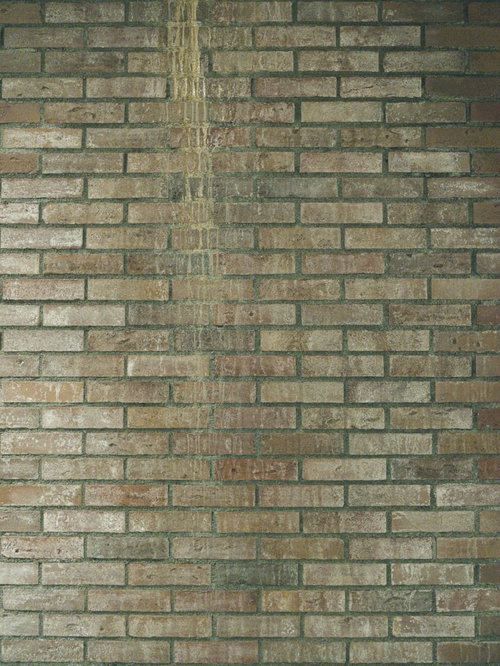 汚れた雨だれが縦に流れるレンガ調外壁のテクスチャー