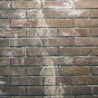 薄汚れた赤茶色のレンガ調外壁のテクスチャーの写真