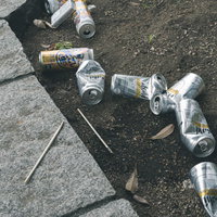 路上飲みで散らかったゴミとアルコール飲料の空き缶の写真