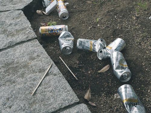 路上飲みで散らかったゴミとアルコール飲料の空き缶
