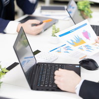 作成した資料を手にとって説明する会議の様子の写真