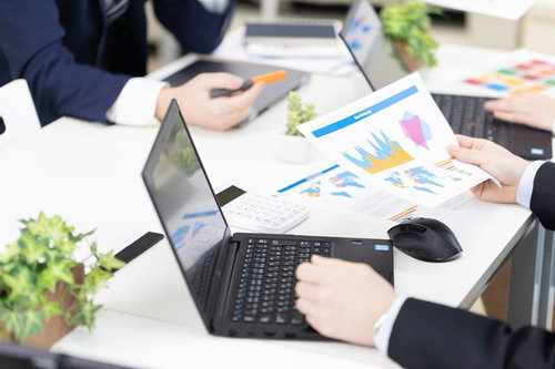 作成した資料を手にとって説明する会議の様子