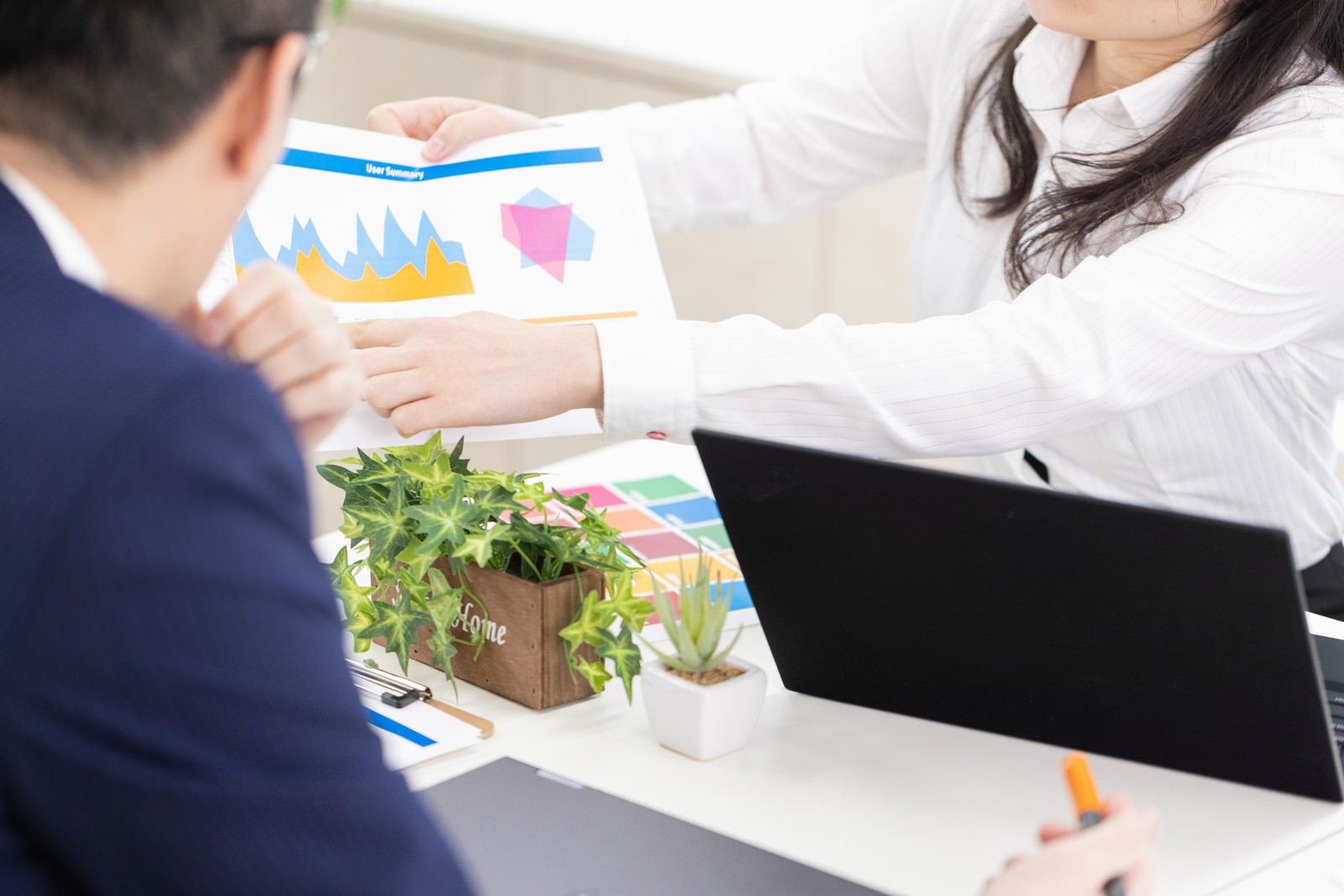 ノートパソコンでグラフを使った改善案をプレゼンしている様子