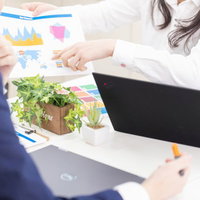 資料を使ってテーブルで上司を説得する打ち合わせの写真