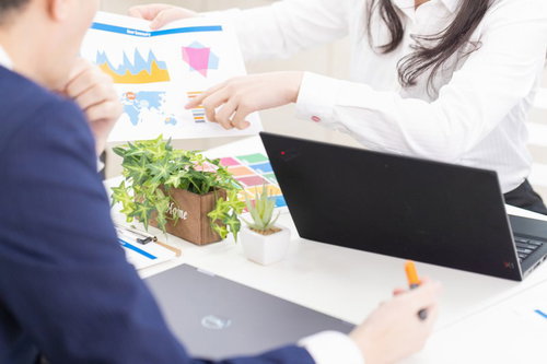 資料を使ってテーブルで上司を説得する打ち合わせ