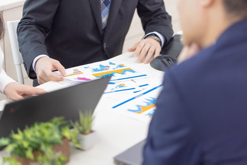 グラフ資料を確認するビジネスマンの会議シーン