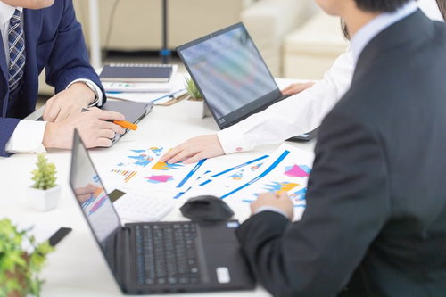 会議室でパソコンと資料を使ったビジネスマンの打ち合わせ