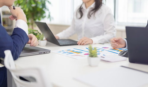 パソコンを囲んで会議する3人のビジネスパーソン